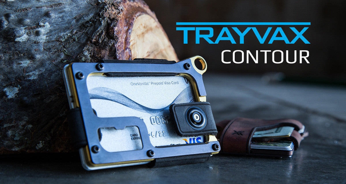 Two Trayvax Contour Wallets Leaning Against a Log