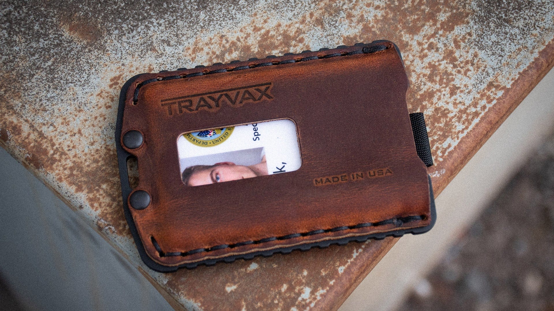 Mississippi Mud Ascent Wallet Laying On Rusted, Textured Table Top With ID Showing Through ID Window