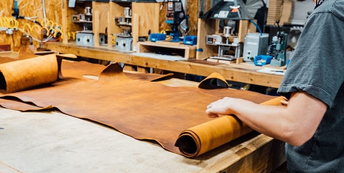 Roll of Horween Top-Grain Tobacco Brown Leather Being Rolled Out On Workstation Ready to Be Stamped