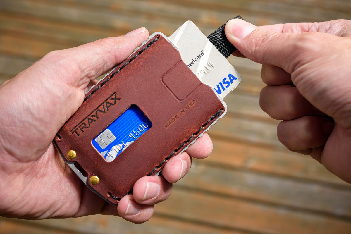 Man Pulling Cards Out of His Brown Ascent Wallet With Background Blurred Out