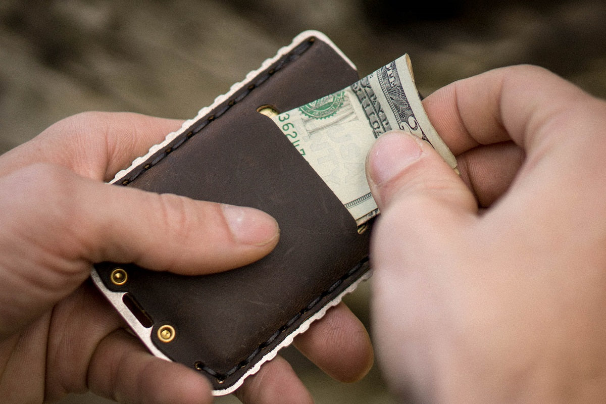 Man Showing Cash Fitting Into the Back of an Ascent Wallet