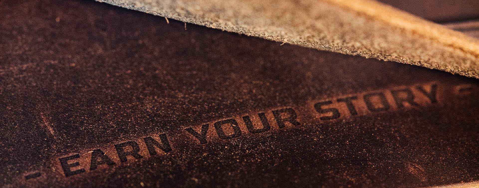Trayvax slogs "earn your story" engraved in horween top-grain leather